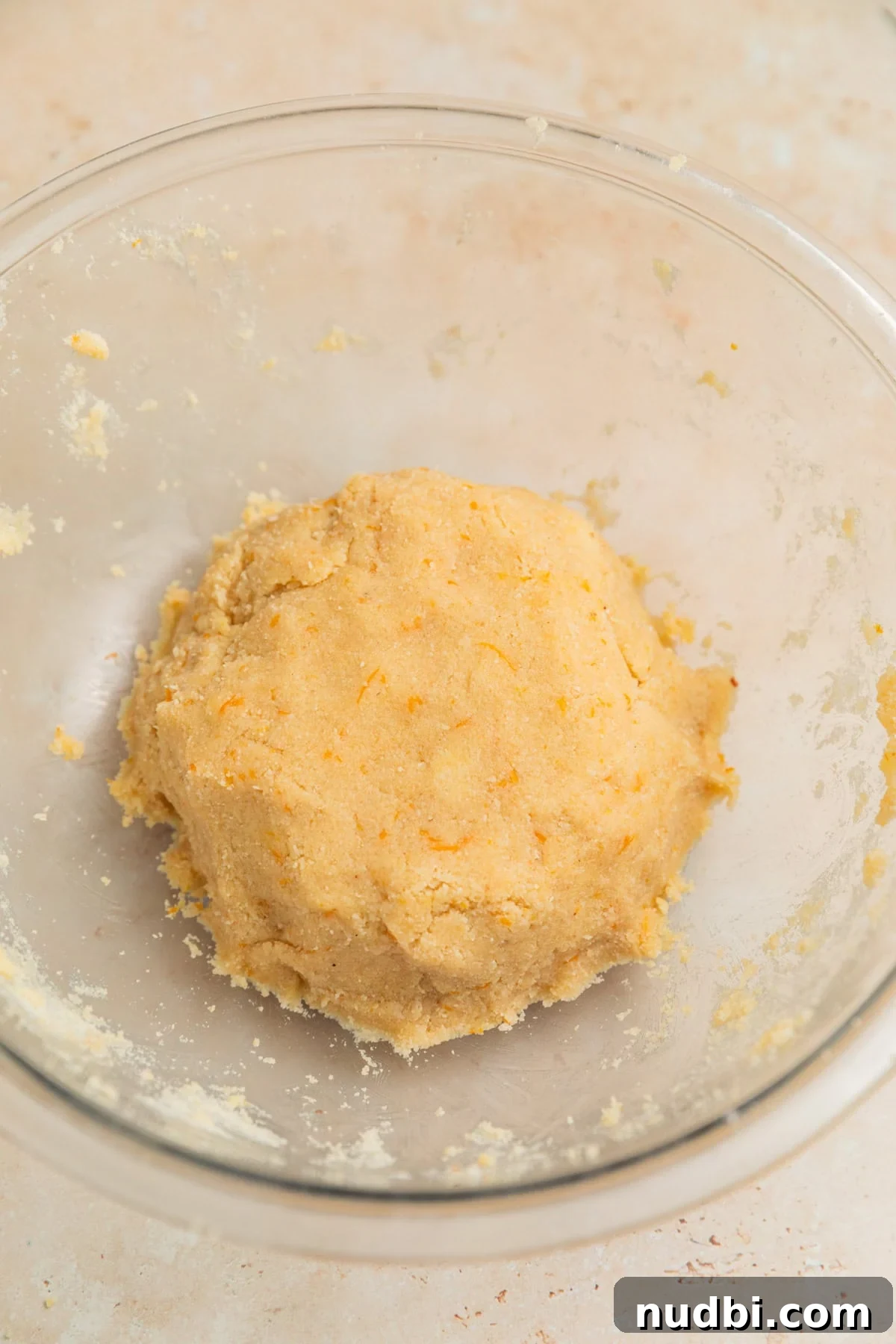 Almond Flour Orange Cookies Recipe — Light Citrus Cookie Guide 6 Ball of orange almond flour cookie dough in glass mixing bowl.