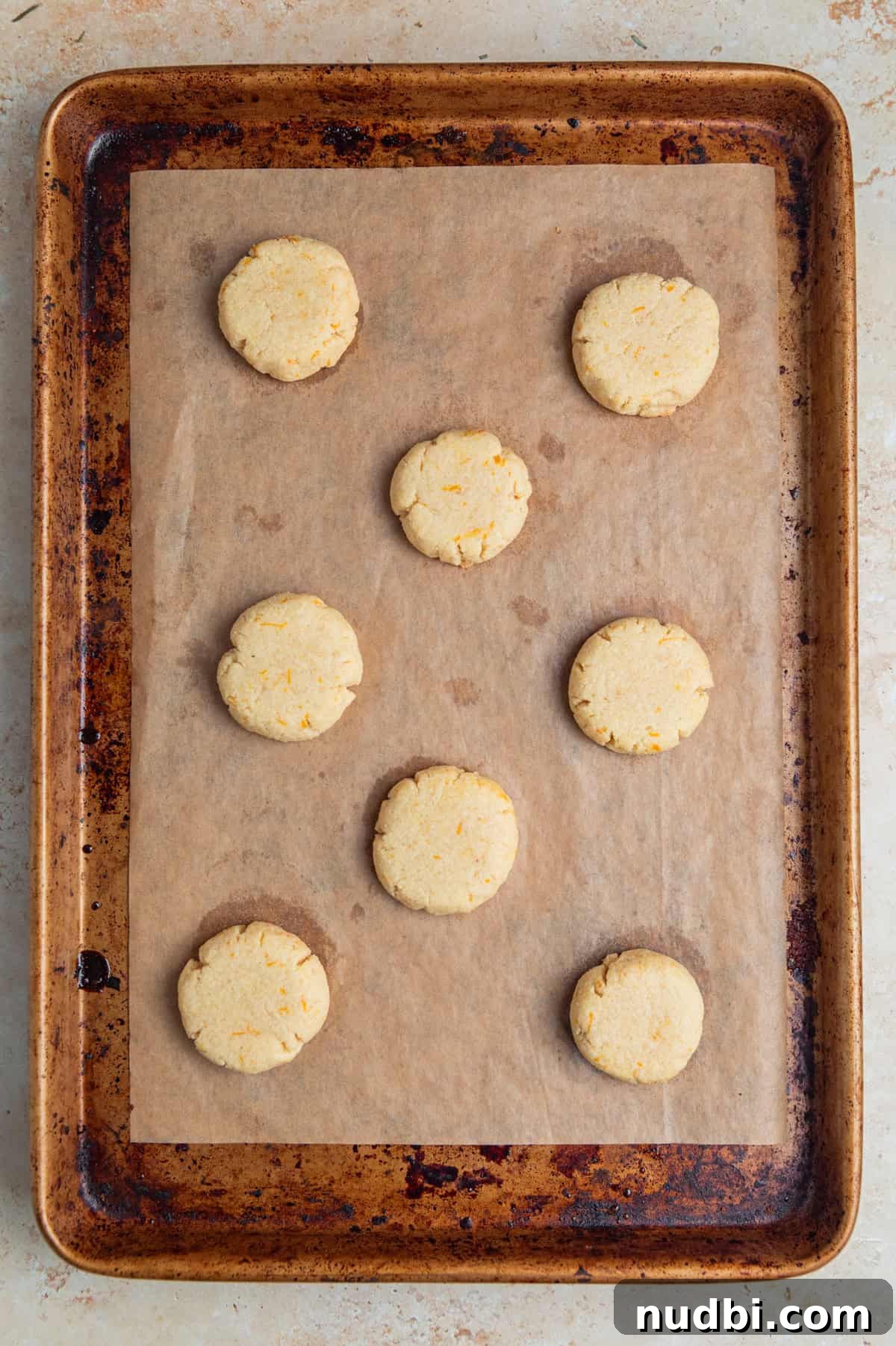 Almond Flour Orange Cookies Recipe — Light Citrus Cookie Guide 8 Baked orange cookies on parchment lined cookie pan.