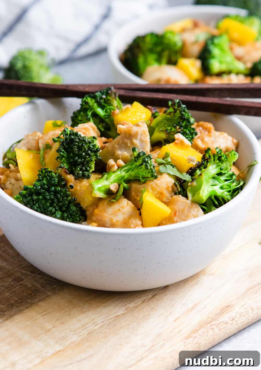 Peanut Mango Chicken Stir-Fry with Jasmine Rice Recipe 4 Peanut Mango Chicken and Broccoli Stir Fry in bowl with chopsticks.