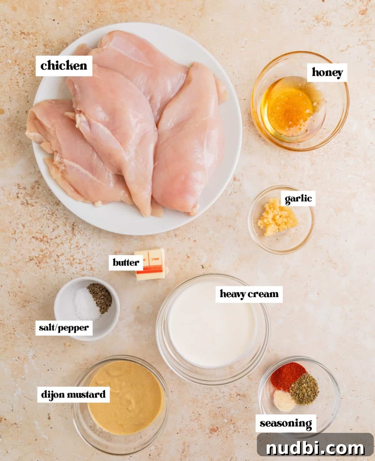 Slow Cooker Honey Mustard Chicken Recipe for Tender, Saucy Results 3 Raw chicken breast, honey, dijon mustard and other ingredients labeled on surface.