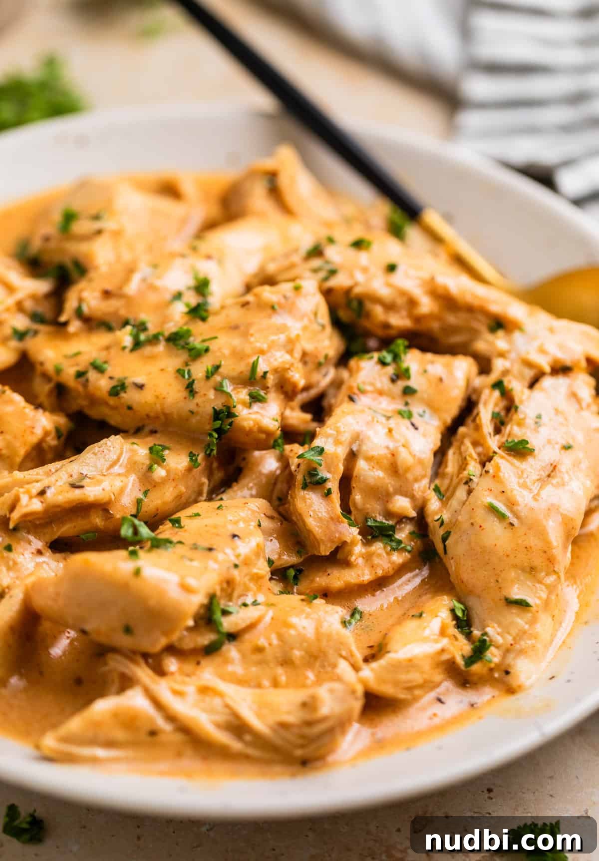 Slow Cooker Honey Mustard Chicken Recipe for Tender, Saucy Results 10 Creamy honey mustard chicken on plate with serving spoon.
