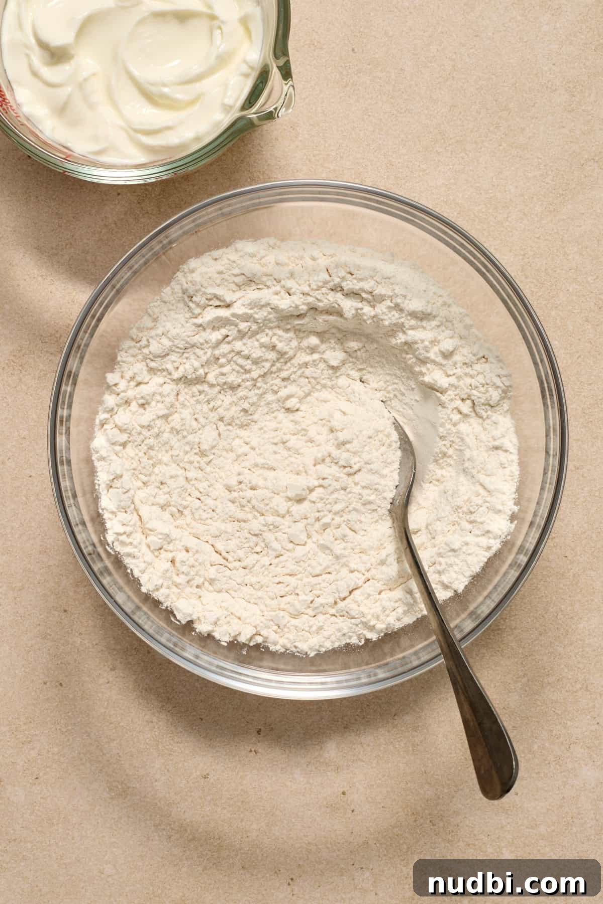 High-Protein Greek Yogurt Bagel Recipe 4 Dry ingredients in glass mixing bowl with spoon.