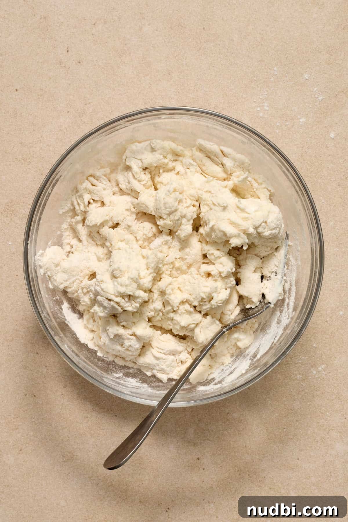 High-Protein Greek Yogurt Bagel Recipe 6 Greek yogurt bagel dough mixture in glass bowl with metal spoon.