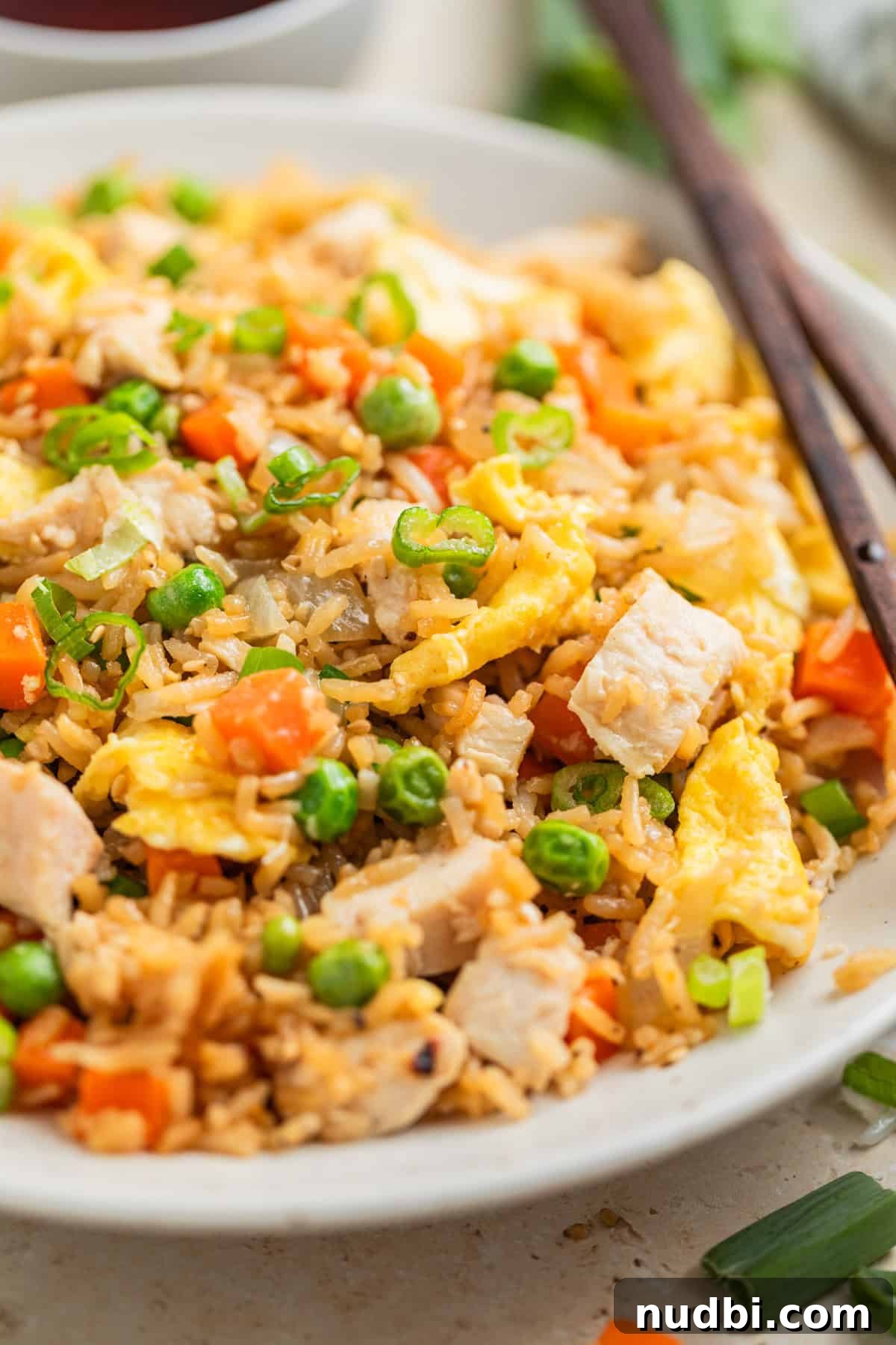 Quick Chicken Fried Rice Recipe for Perfect Weeknight Meals 2 Rotisserie chicken fried rice served on white plate with chopsticks.