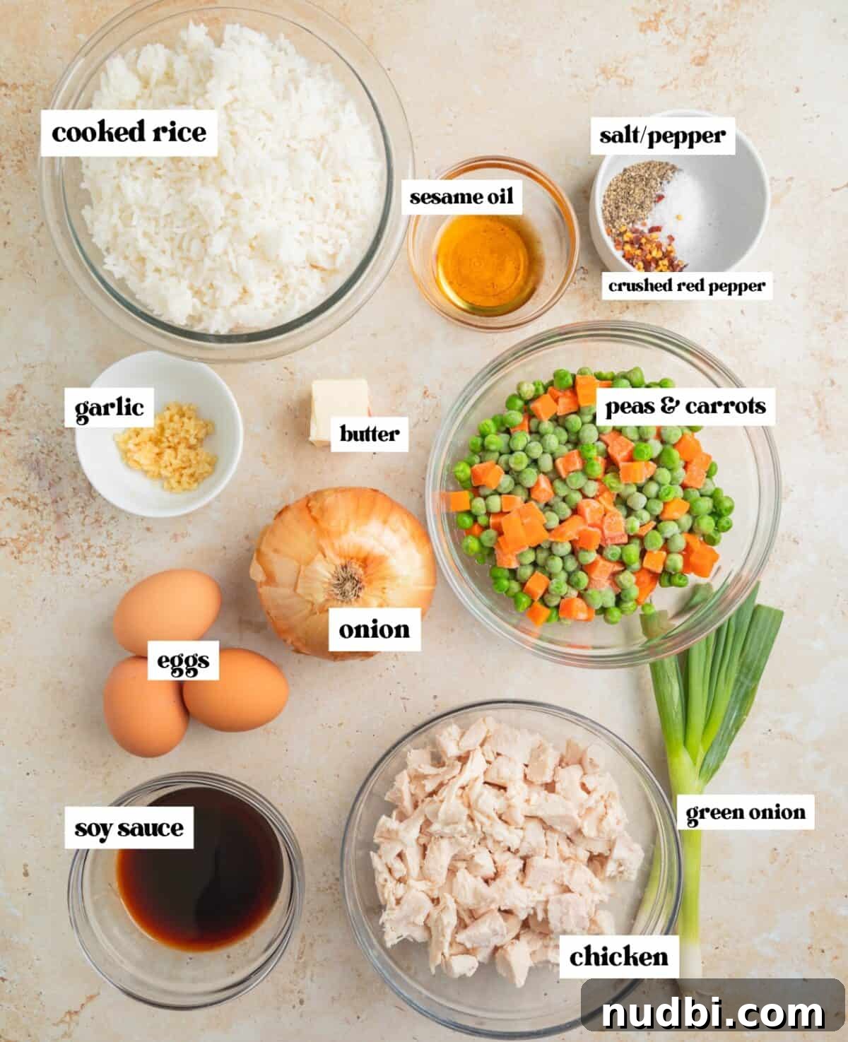 Quick Chicken Fried Rice Recipe for Perfect Weeknight Meals 3 Cooked white rice, frozen peas and carrots and other ingredients arranged on surface and labeled.