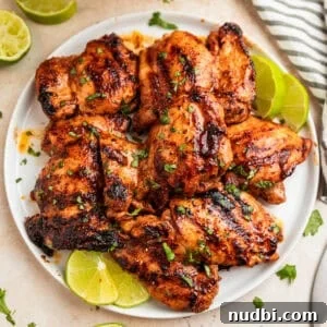 Zesty Chili Lime Chicken Recipe for Tender Grilled Chicken 13 Overhead view of chili lime chicken on white plate with lime slices.