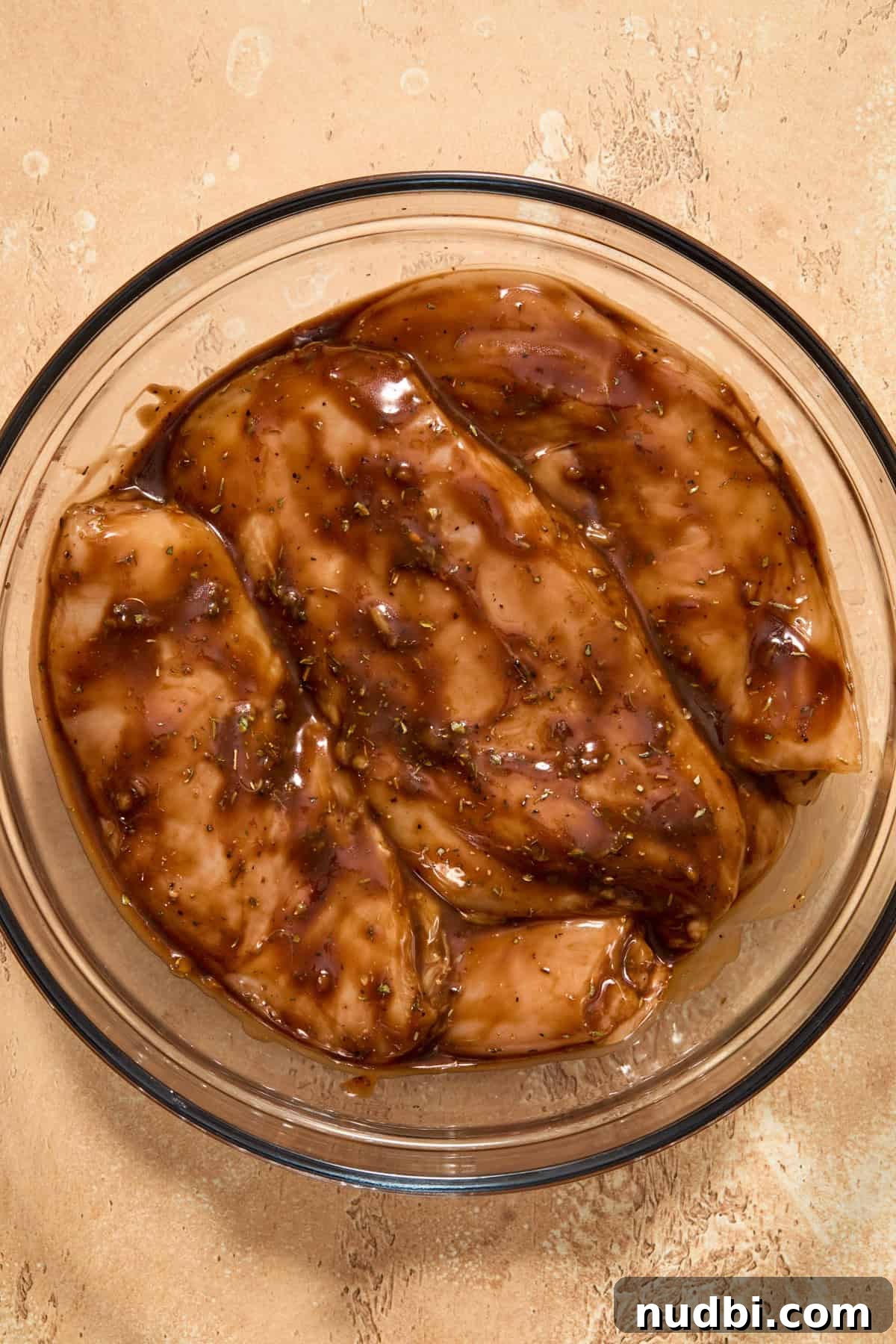 Bowl with chicken breast sitting in balsamic marinade.