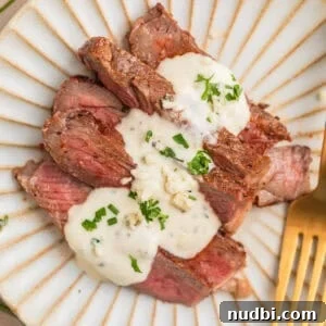 Grilled Ribeye with Creamy Gorgonzola Sauce Recipe 15 Sliced grilled ribeye steak sliced and served on plate with gorgonzola sauce.