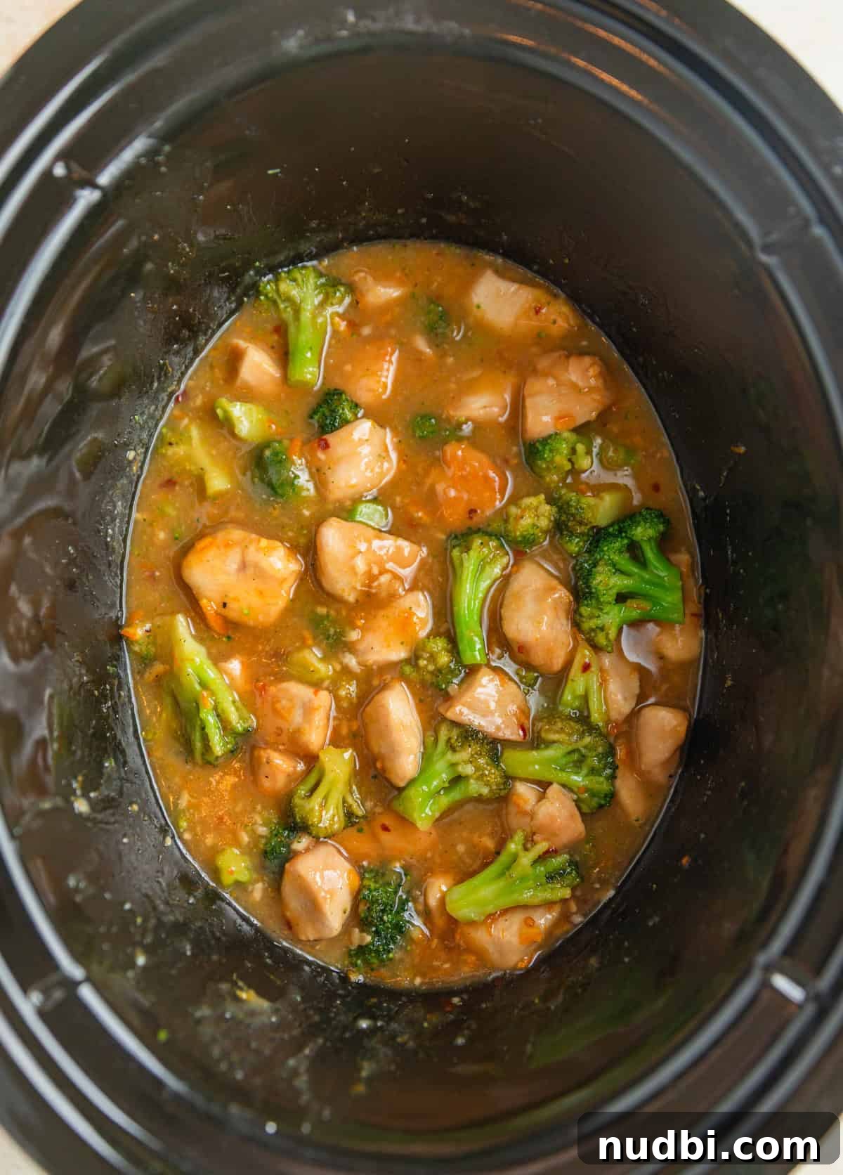 Slow-Cooker Orange Chicken Recipe for Tender, Saucy Chicken 11 Slow cooker pot with orange broccoli and chicken cooked in sauce.