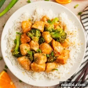 Slow-Cooker Orange Chicken Recipe for Tender, Saucy Chicken 17 Orange chicken and broccoli served over white rice on plate.