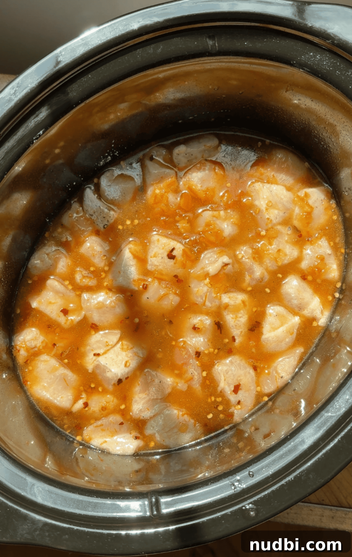 Slow-Cooker Orange Chicken Recipe for Tender, Saucy Chicken 8 Orange sauce poured over chicken in crock pot.