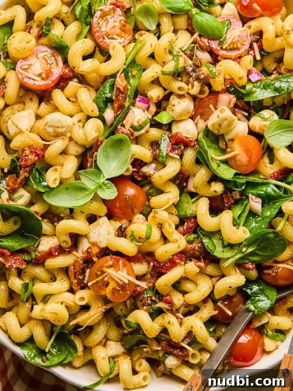 Grilled Corn Chopped Salad with Lime and Cotija 12 Sun dried tomato pasta salad with basil, spinach, parmesan and other ingredients in salad bowl.
