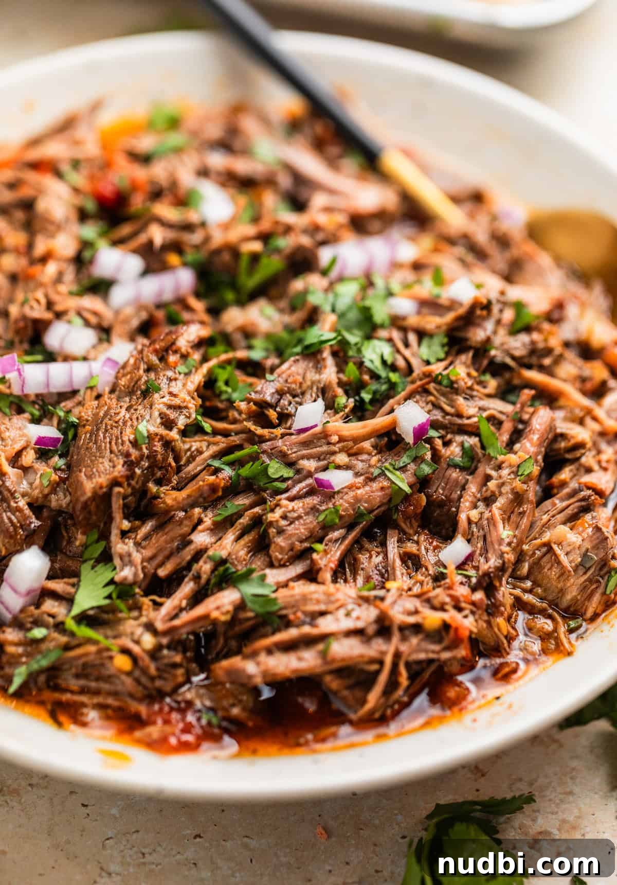 Slow-Cooker Shredded Beef Tacos Recipe for Tender, Flavorful Meat 9 Slow cooker shredded beef tacos in serving plater with spoon.
