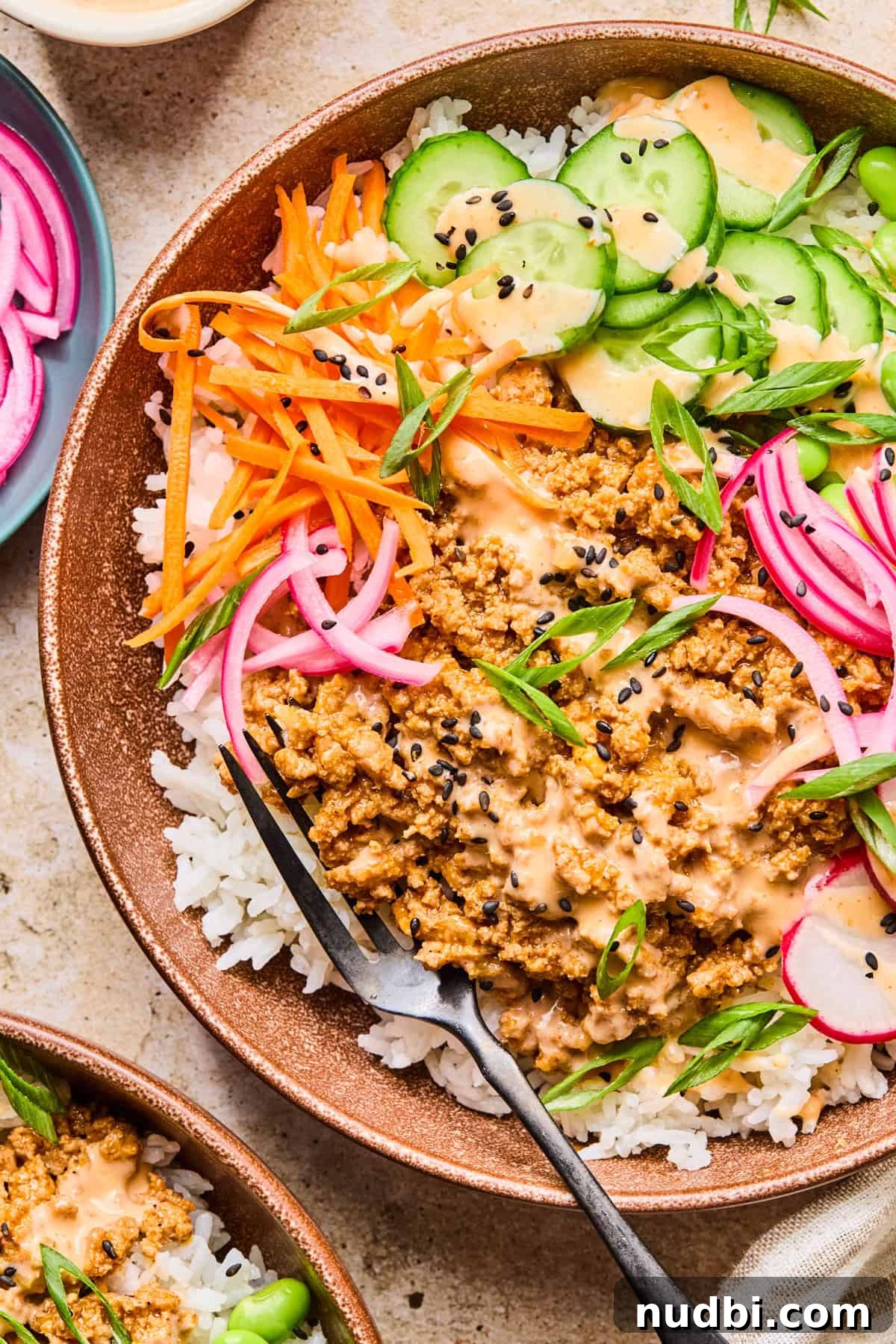 Savory Ground Turkey Rice Bowls with Veggies and Soy-Ginger Sauce 2 Ground turkey rice bowl topped with bang bang sauce and sesame seeds.
