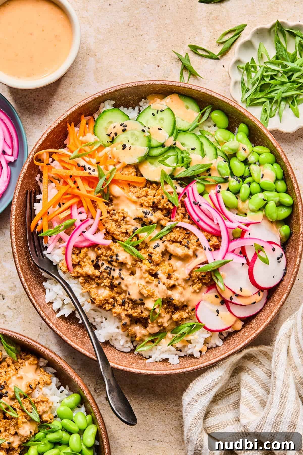Savory Ground Turkey Rice Bowls with Veggies and Soy-Ginger Sauce 8 Ground turkey mixture in bowl with rice, mukimame, cucumber and sauce.