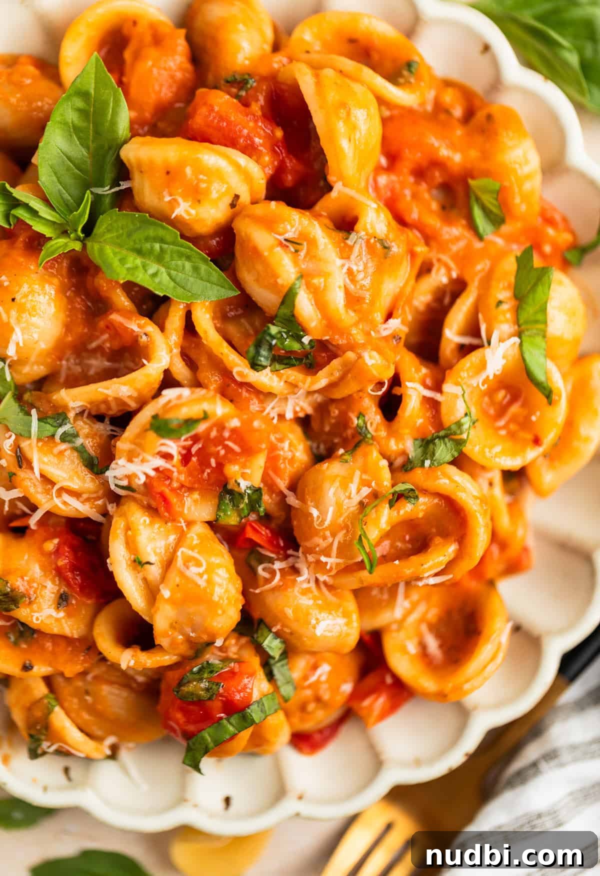 Quick Cherry Tomato Pasta Recipe for Fresh Weeknight Dinners 12 Plate with fresh cherry tomato pasta topped with chopped basil and grated parmesan cheese.