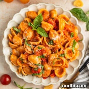 Quick Cherry Tomato Pasta Recipe for Fresh Weeknight Dinners 13 Plate with cherry tomato pasta topped with fresh chopped basil and parmesan.