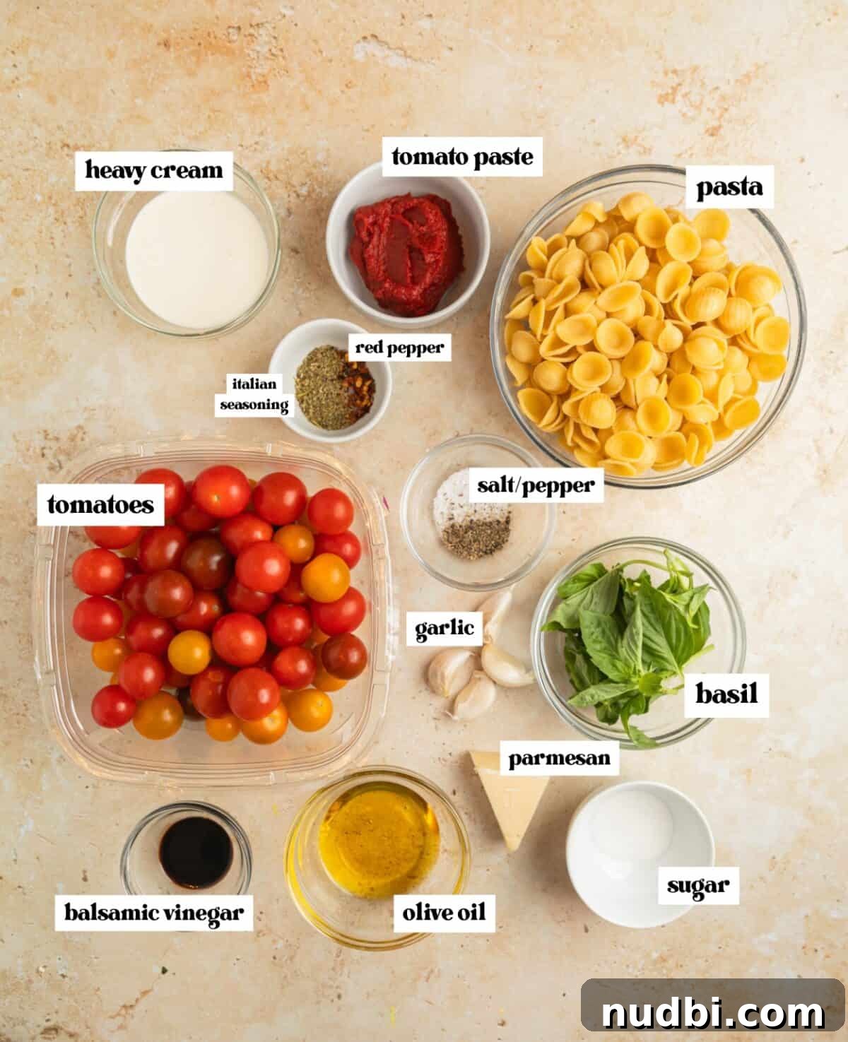 Quick Cherry Tomato Pasta Recipe for Fresh Weeknight Dinners 3 Ingredients needed to make recipe arranged on surface including cherry tomatoes, basil, olive oil and other ingredients.