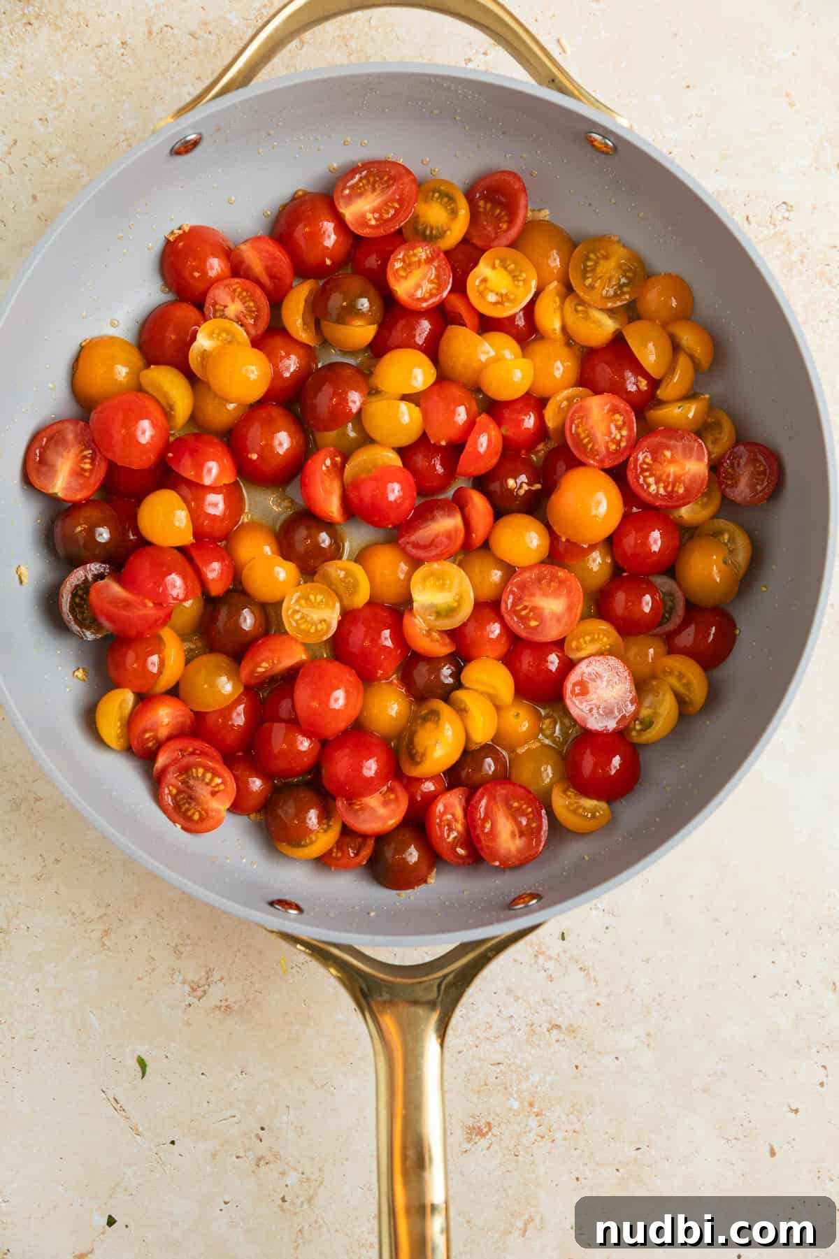 Quick Cherry Tomato Pasta Recipe for Fresh Weeknight Dinners 5 Sliced cherry tomatoes added to pan with olive oil and garlic.