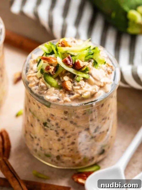 Grandma’s Zucchini Bread Recipe (Even Better) 16 Glass jar with zucchini bread overnight oatmeal and white spoons beside it along with pecans and cinnamon sticks.