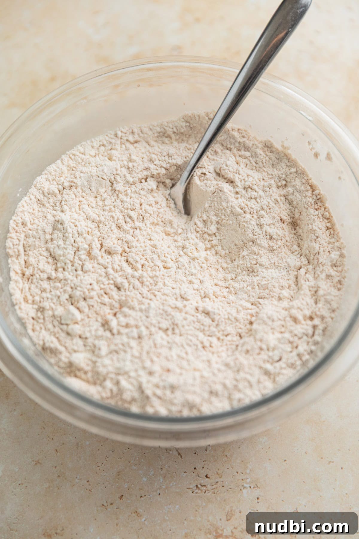 Grandma’s Zucchini Bread Recipe (Even Better) 8 Dry ingredients in glass bowl with spoon.
