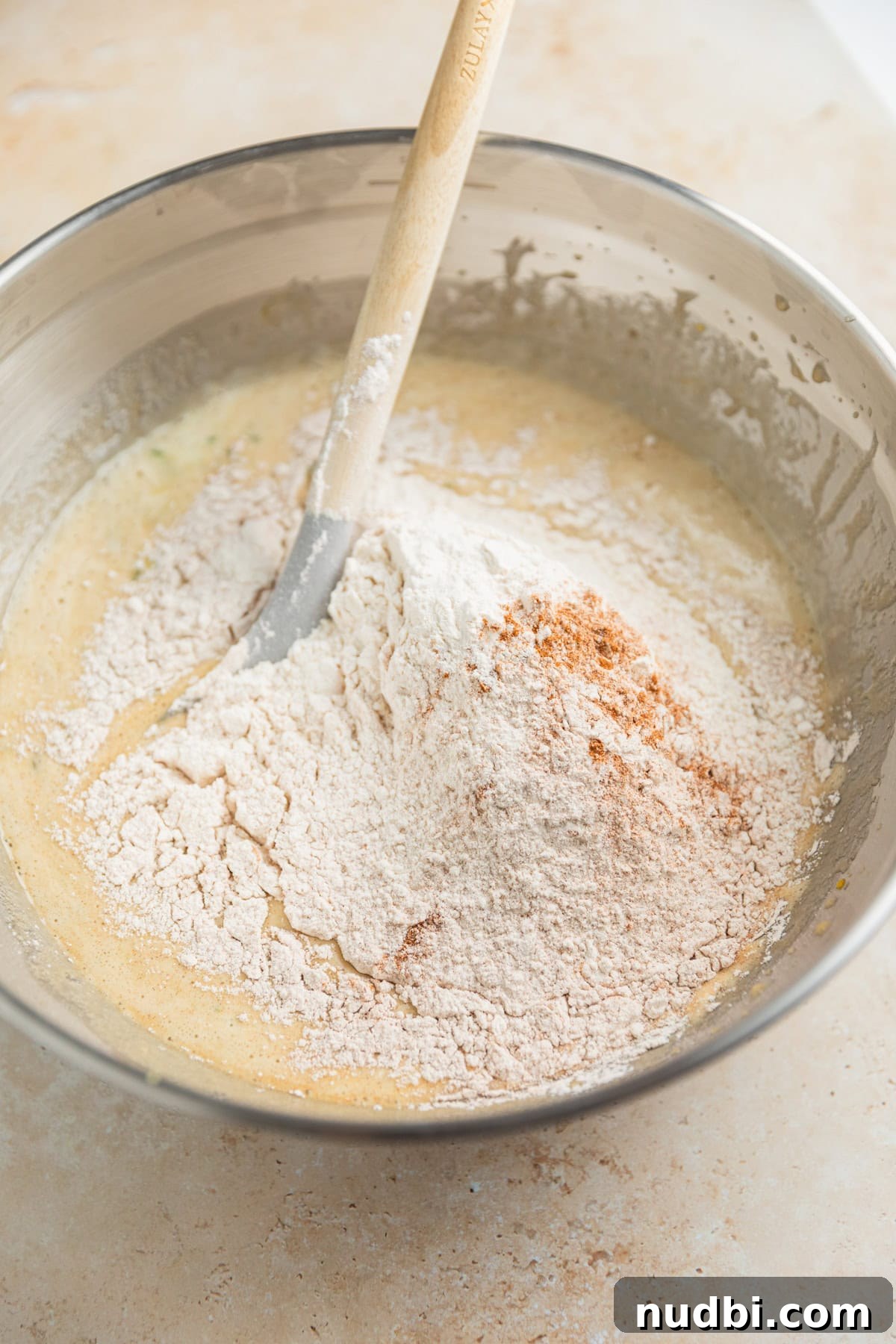 Grandma’s Zucchini Bread Recipe (Even Better) 9 Dry ingredients added to wet ingredients in glass mixing bowl.