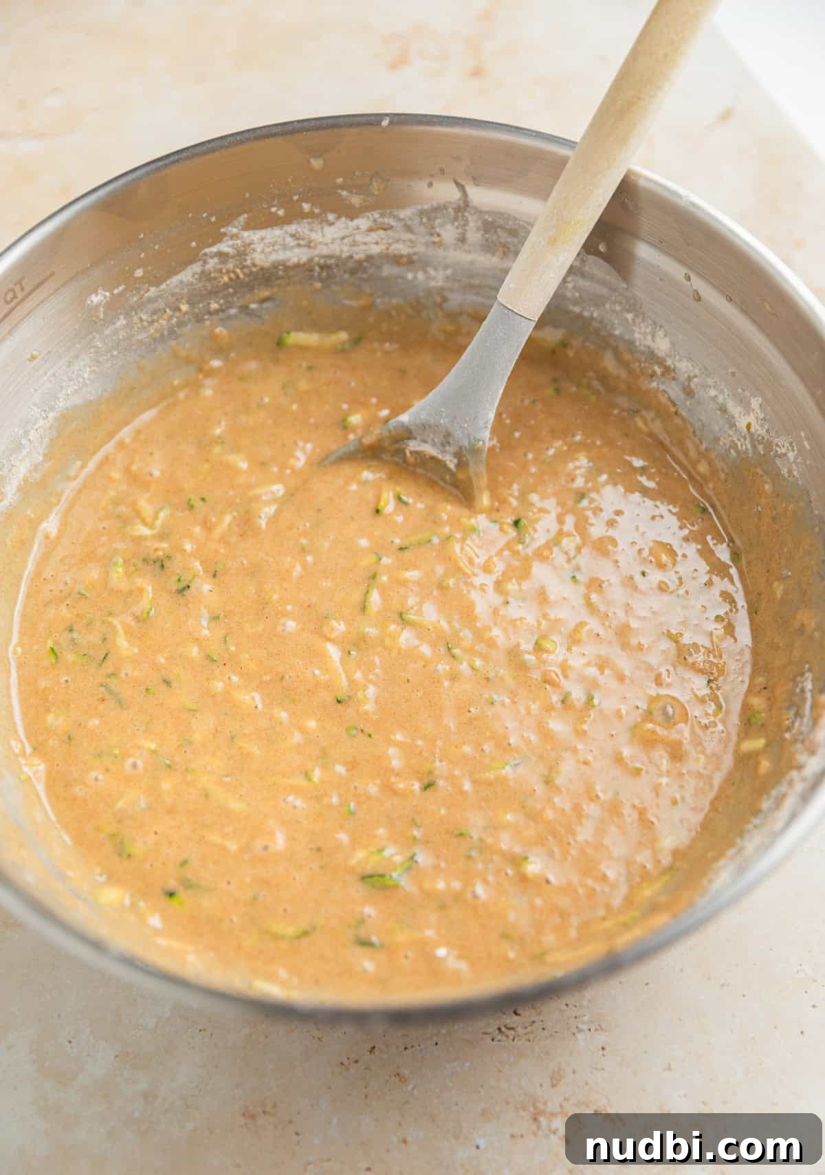 Grandma’s Zucchini Bread Recipe (Even Better) 10 Prepared zucchini bread batter in bowl with wooden spoon.
