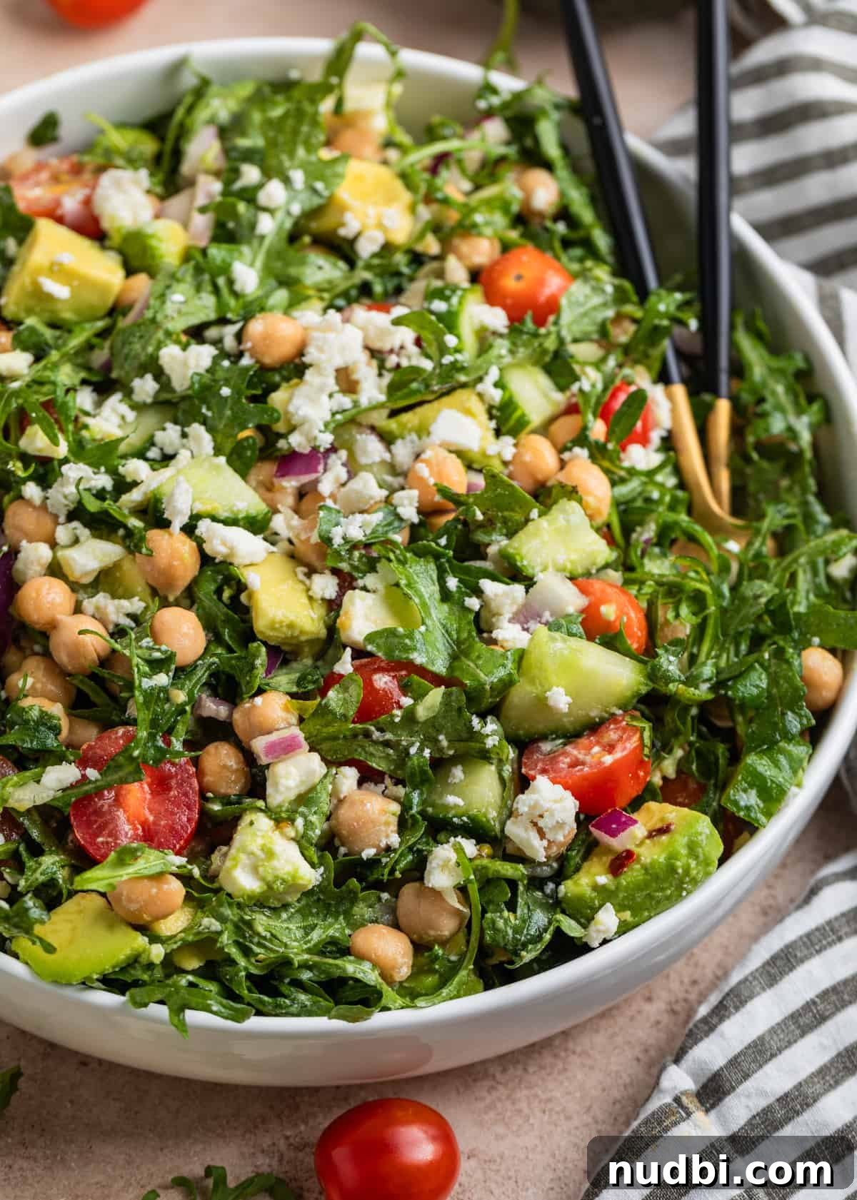 Creamy Chickpea and Avocado Salad with Lemon Dressing 2 White dish with arugula, chickpea and avocado salad topped with feta cheese.
