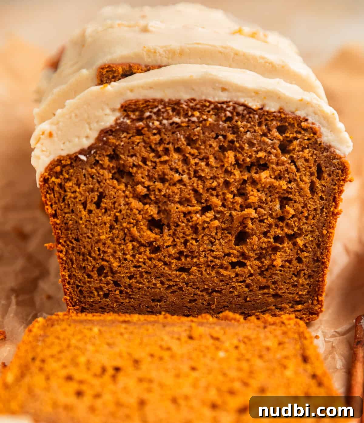 Pumpkin Bread Made from Cake Mix: Quick Moist Recipe 15 Frosted pumpkin bread loaf with open slice showing texture.