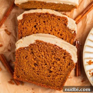 Pumpkin Bread Made from Cake Mix: Quick Moist Recipe 20 Frosted pumpkin bread slices on parchment with cinnamon sticks.