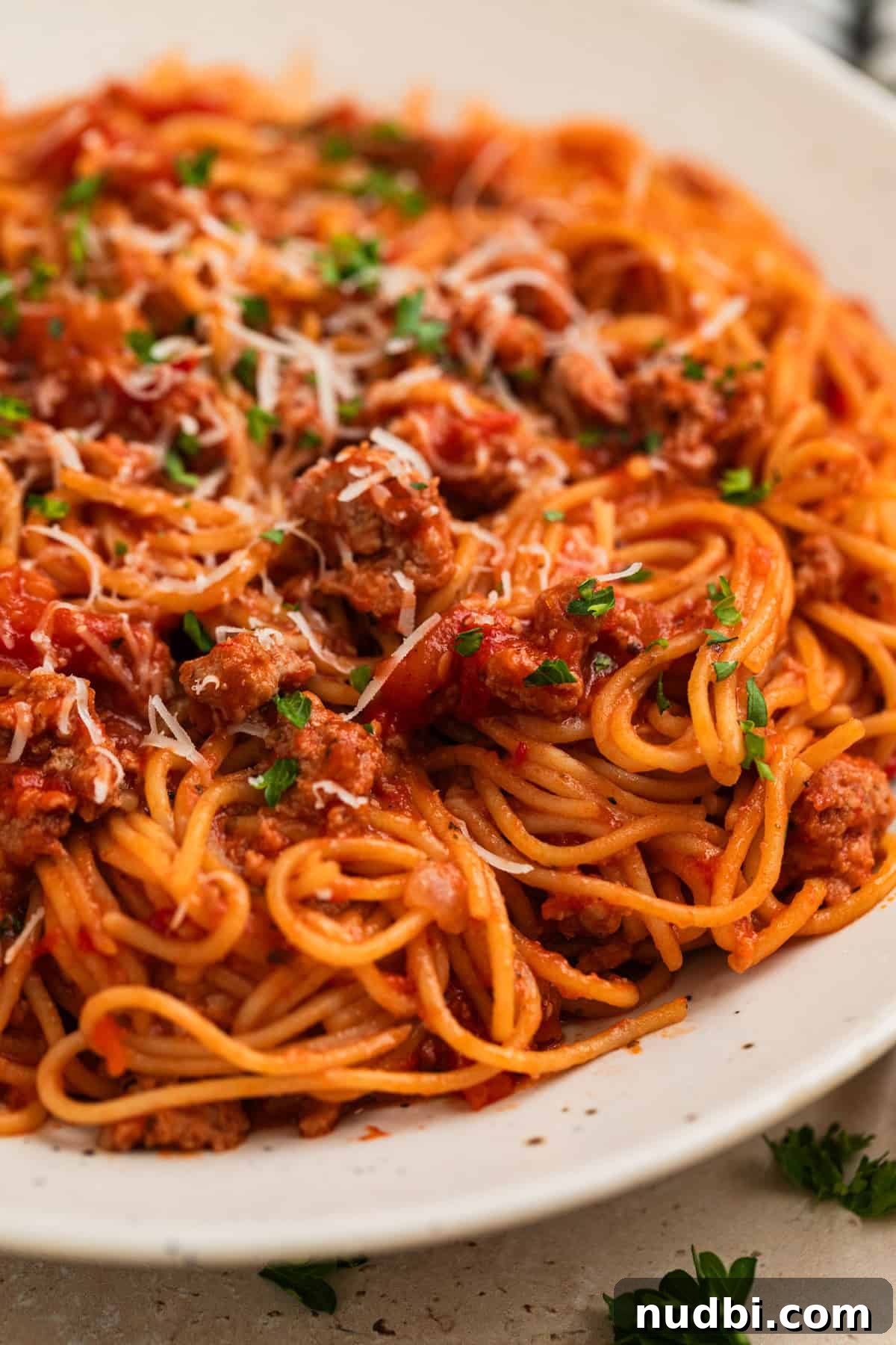One-Pot Instant Pot Spaghetti Recipe for Quick Weeknight Dinners 2 Plate with spaghetti and meat sauce topped with chopped parsley and freshly grated parmesan.