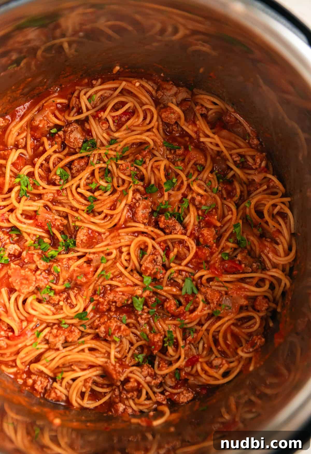 One-Pot Instant Pot Spaghetti Recipe for Quick Weeknight Dinners 9 Spaghetti in pressure cooker with meat sauce and topped with chopped parsley.