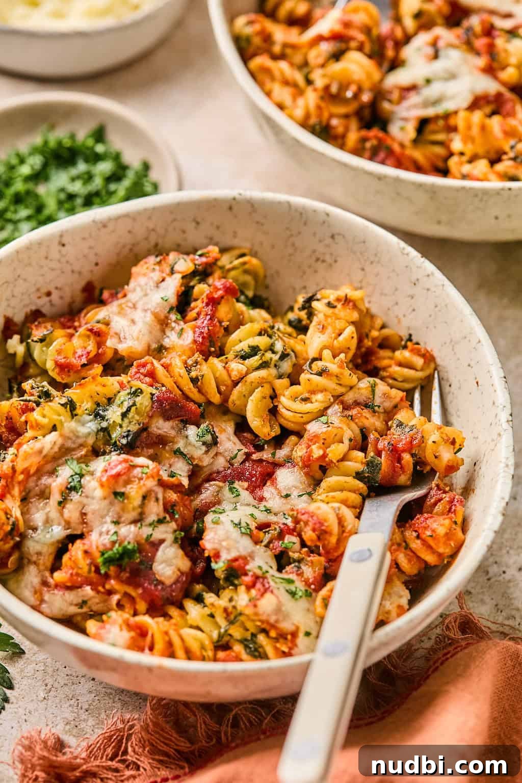 Spinach Baked Pasta with Creamy Cheese and Garlic 10 Bowl with cottage cheese, tomato and spinach baked pasta and fork propped in the bowl.