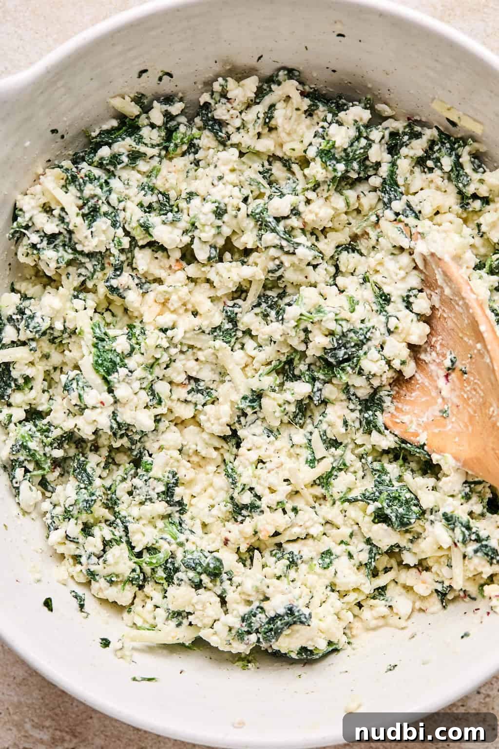 Spinach Baked Pasta with Creamy Cheese and Garlic 8 Spinach pasta bake cheese mixture prepped in bowl with spoon.