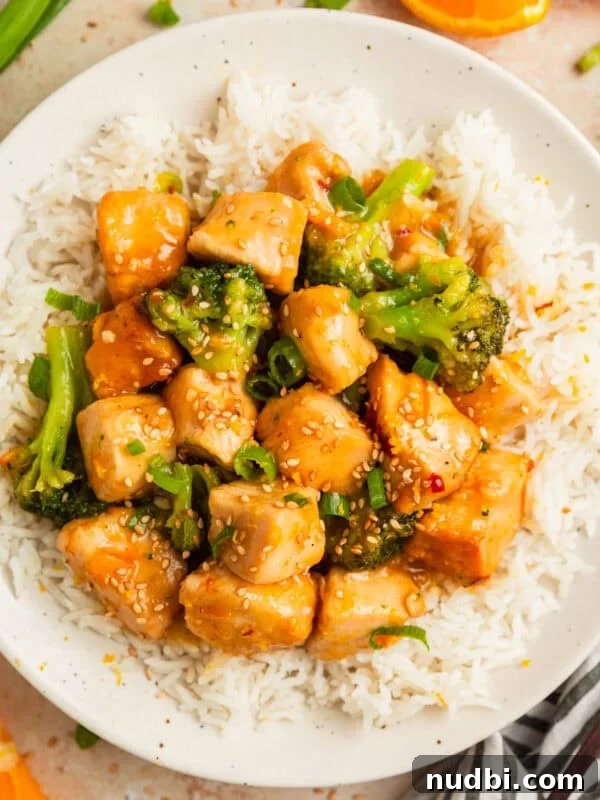 Slow Cooker Apricot-Glazed Chicken Recipe 11 Orange chicken and broccoli served over white rice on plate.