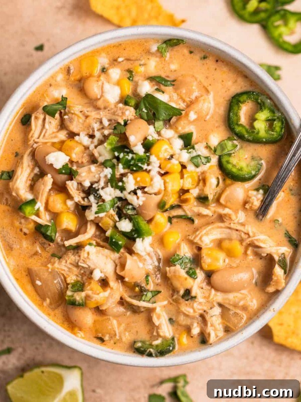 Slow Cooker Apricot-Glazed Chicken Recipe 12 White bowl with white chicken chili with toppings and spoon.