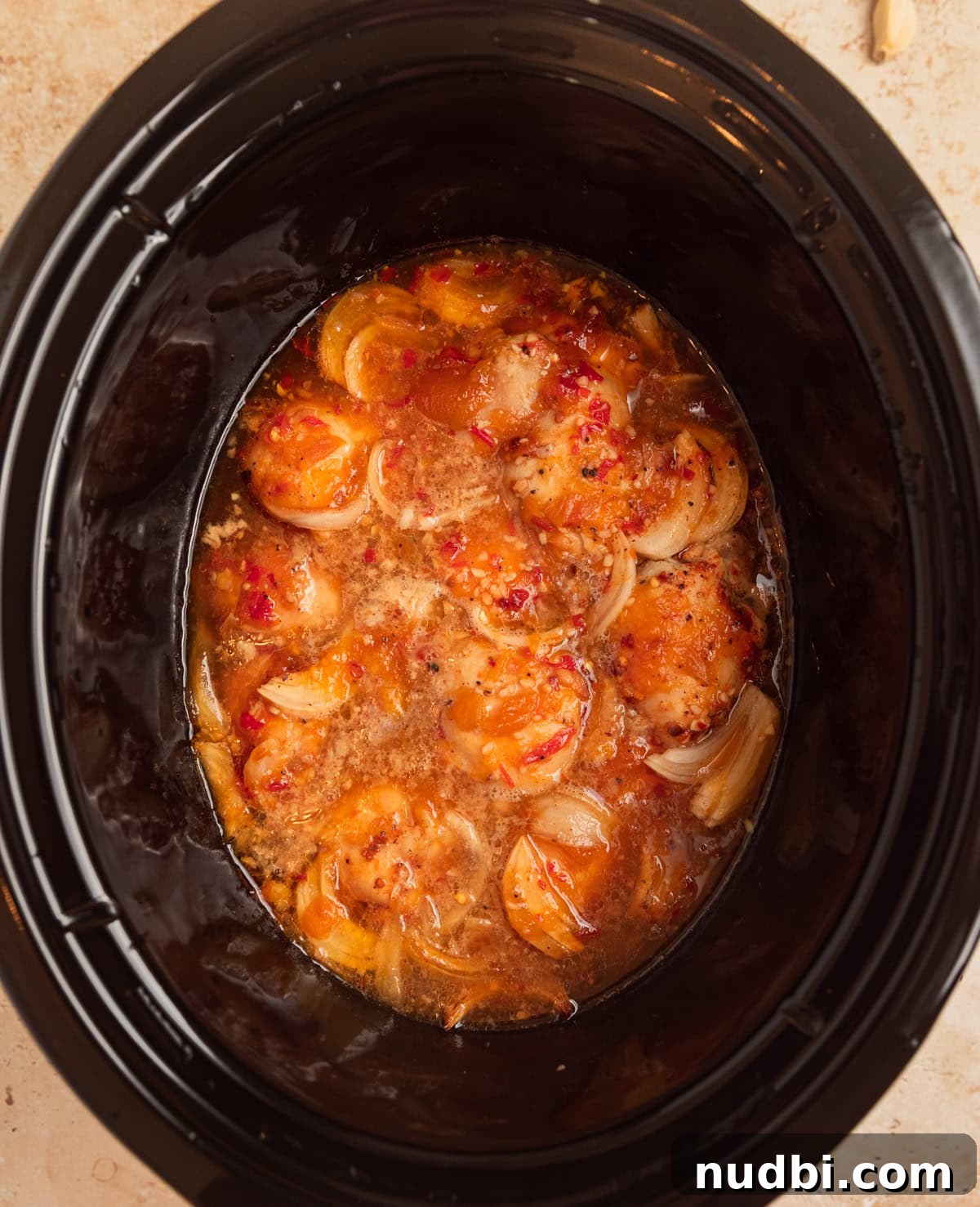 Slow Cooker Apricot-Glazed Chicken Recipe 7 Cooked chicken thighs in sauce in slow cooker pot.