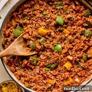 Simple ground turkey pepper skillet dinner in pan with wooden spoon.