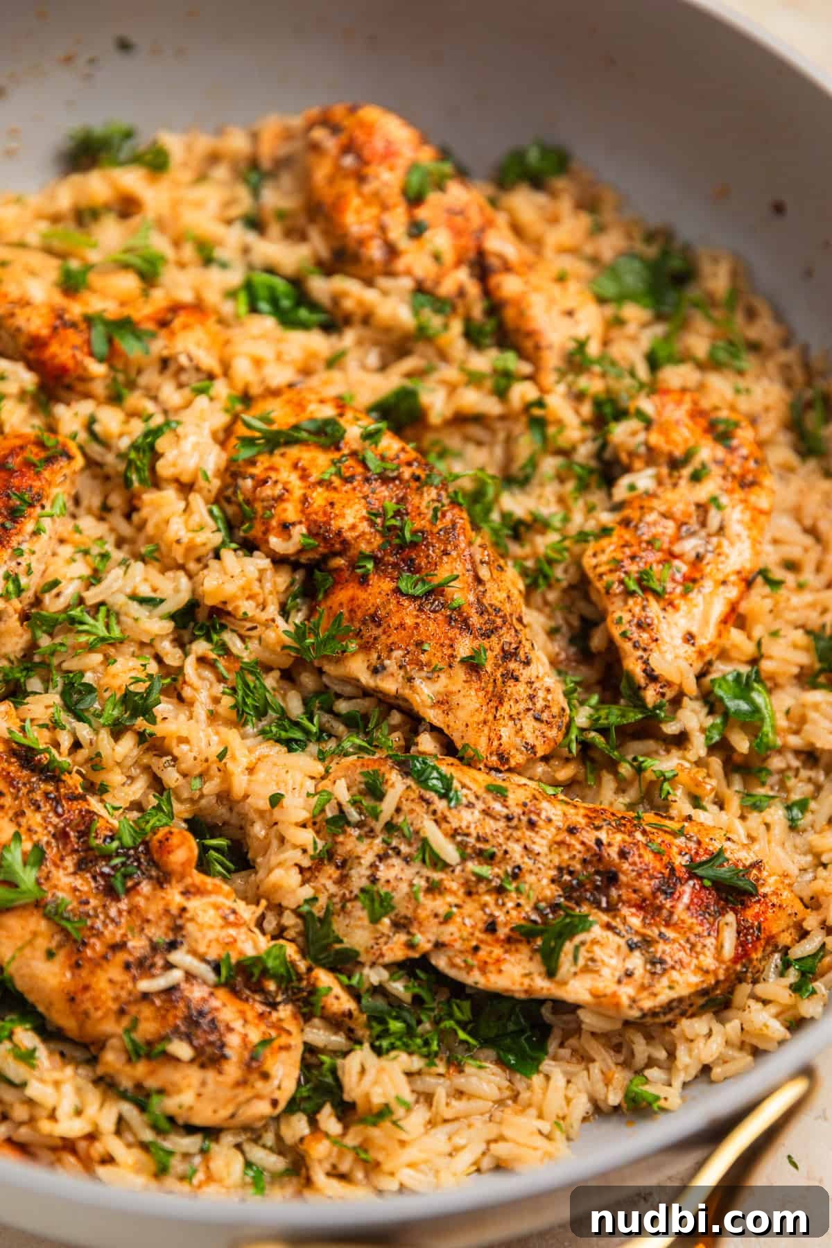One-Pan Chicken and Rice Skillet Recipe for Flavorful Weeknights 2 Pan with chicken and rice covered with chopped parsley.