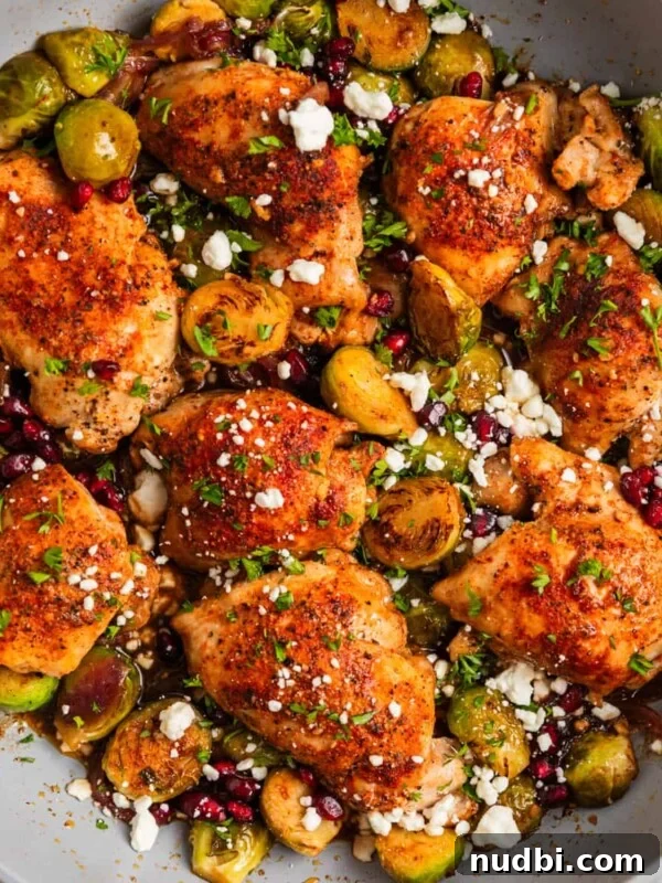 One-Pan Chicken and Rice Skillet Recipe for Flavorful Weeknights 11 Overhead view of pan with cooked chicken thighs and brussel sprouts topped with goat cheese.