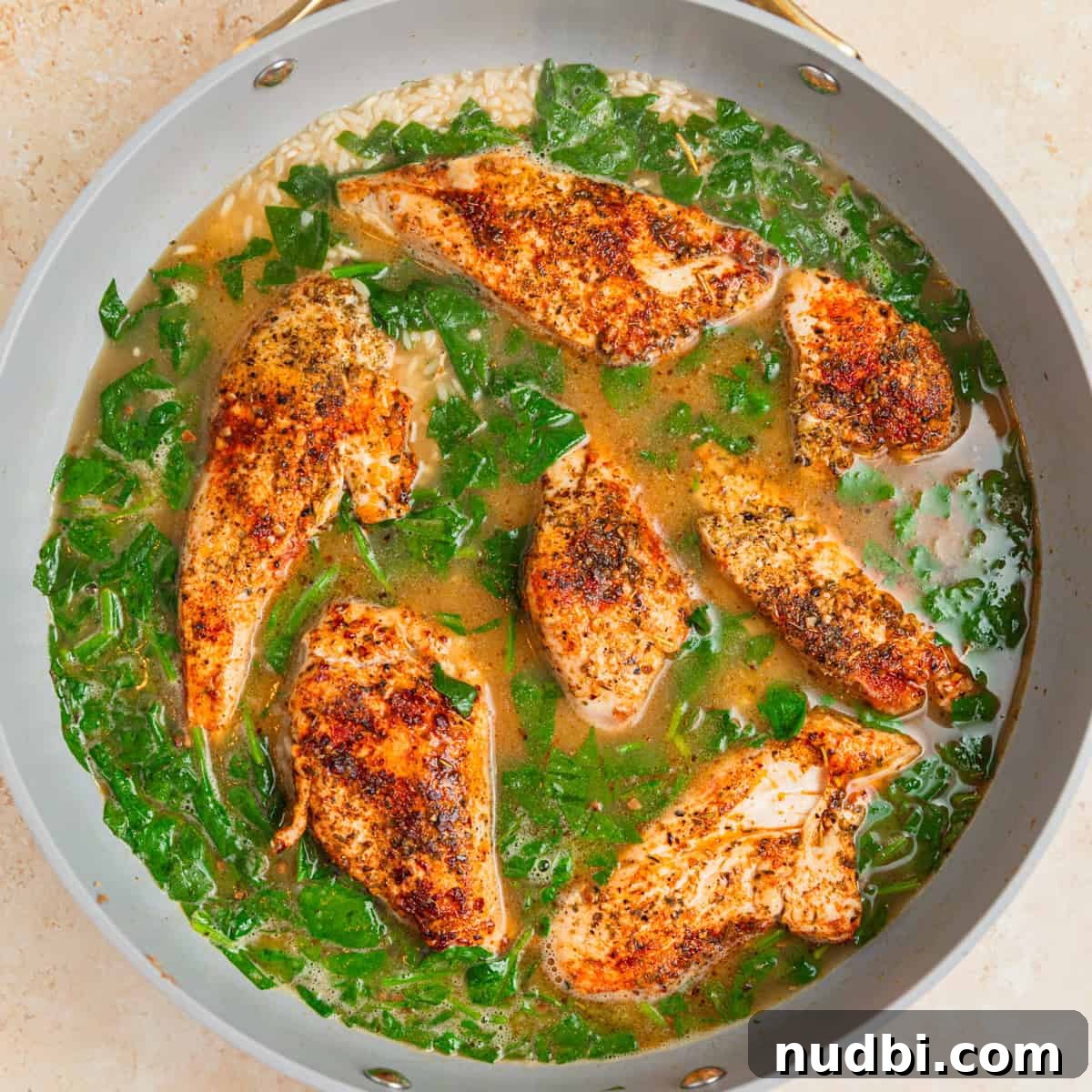 One-Pan Chicken and Rice Skillet Recipe for Flavorful Weeknights 8 Chicken pieces added to pan with broth and rice.
