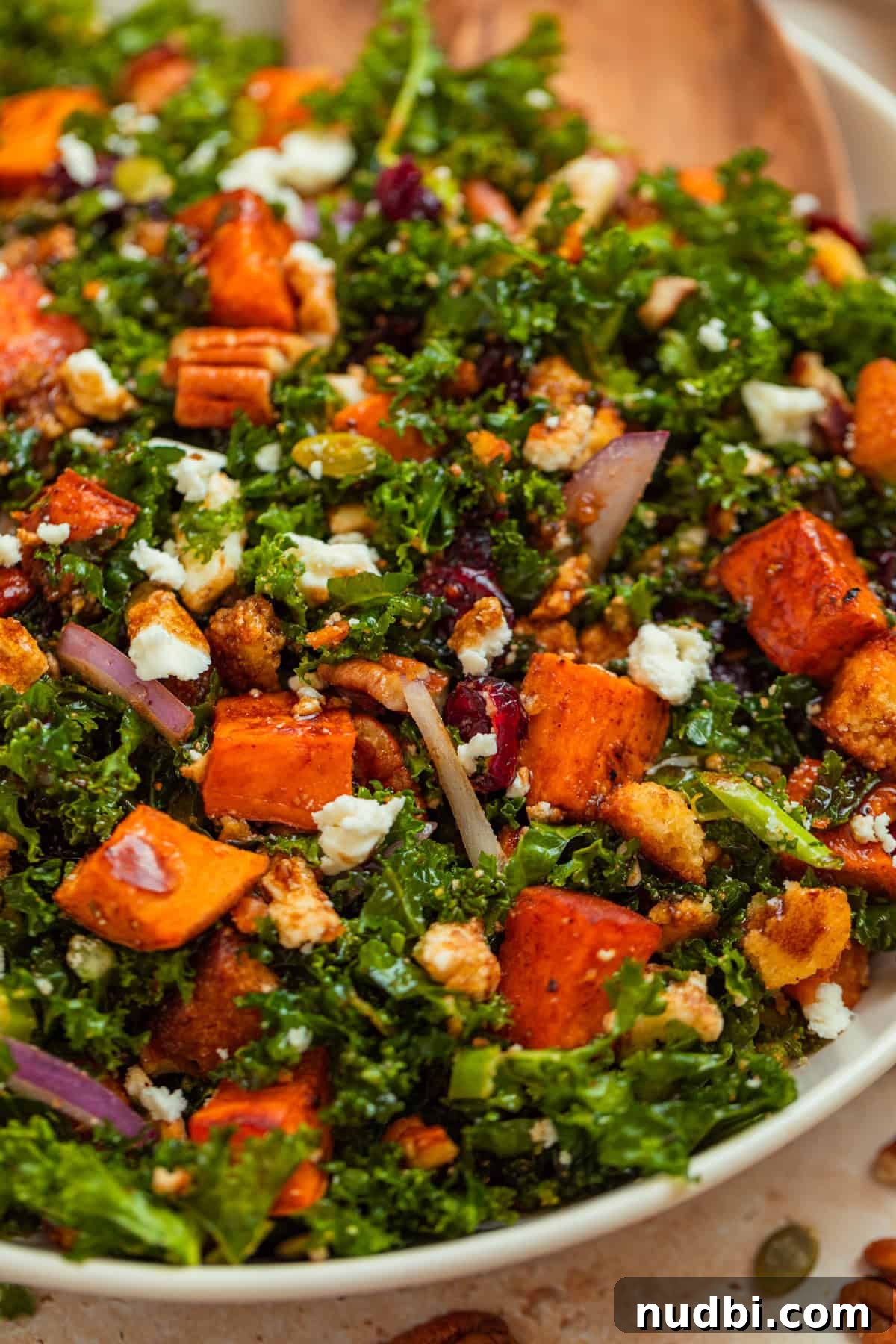 Roasted Sweet Potato and Kale Salad with Maple Dijon Dressing 2 Sweet potato kale salad in serving platter topped with feta, cornbread croutons and more.