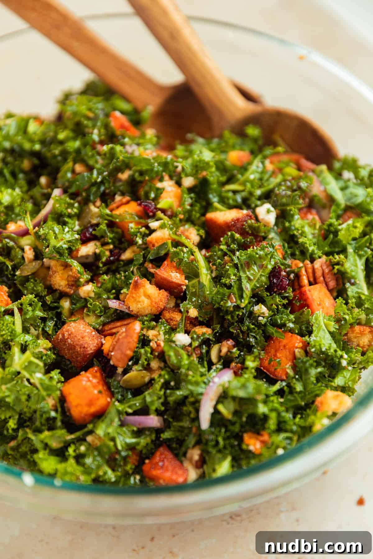 Roasted Sweet Potato and Kale Salad with Maple Dijon Dressing 12 Dressing added to kale salad and tossed in with wood spoons.