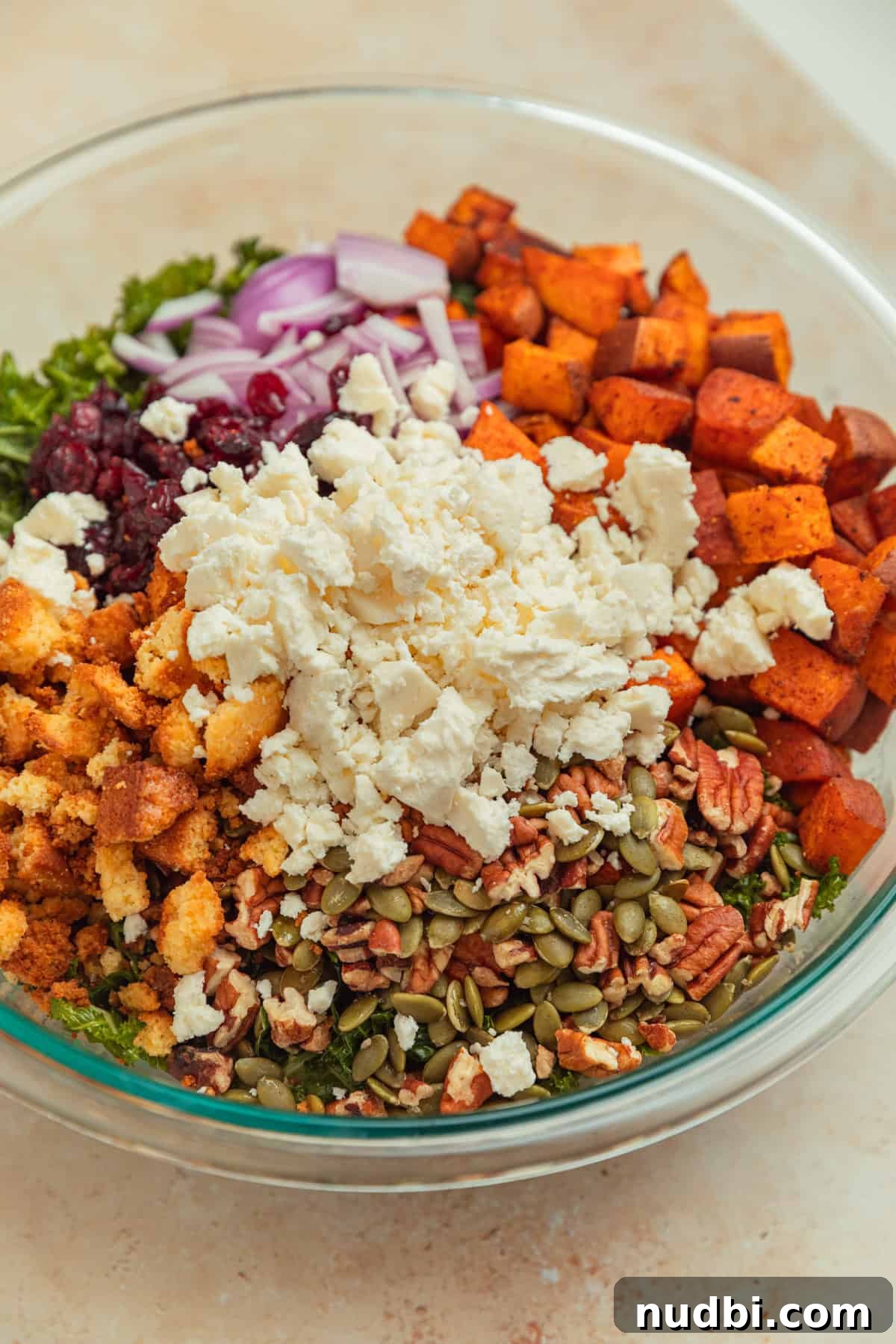 Roasted Sweet Potato and Kale Salad with Maple Dijon Dressing 10 Kale salad in bowl with cornbread croutons, cranberries, sweet potatoes and feta.