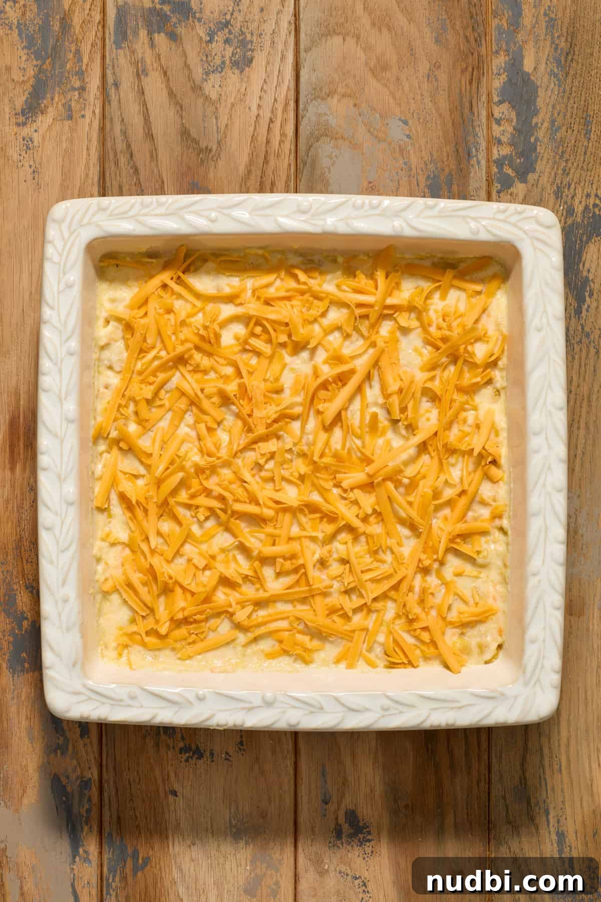 Cheesy Cornbread Casserole Recipe for Comforting Weeknight Dinner 11 Cheese topped over cornbread casserole batter before baking.