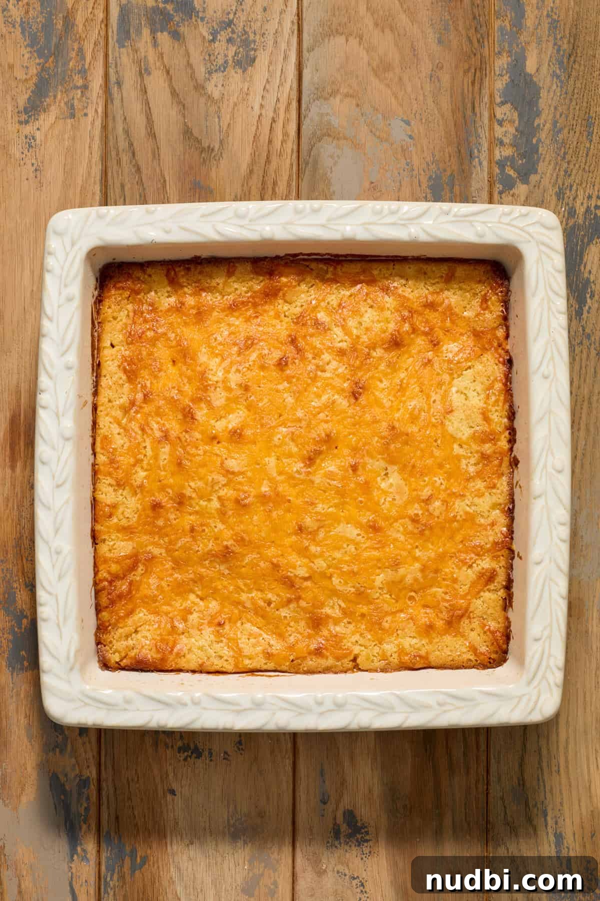 Cheesy Cornbread Casserole Recipe for Comforting Weeknight Dinner 12 Cheesy cornbread casserole baked in square baking pan.