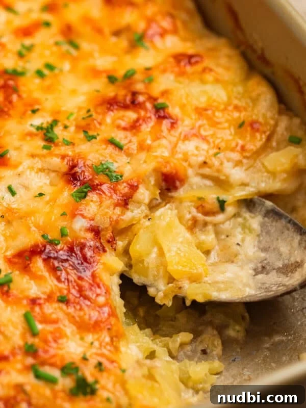 Cheesy Cornbread Casserole Recipe for Comforting Weeknight Dinner 15 Gruyere scalloped potatoes in pan with serving spoon.