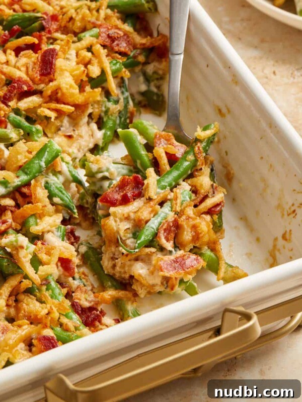 Bacon and green bean casserole in pan with serving spoon.