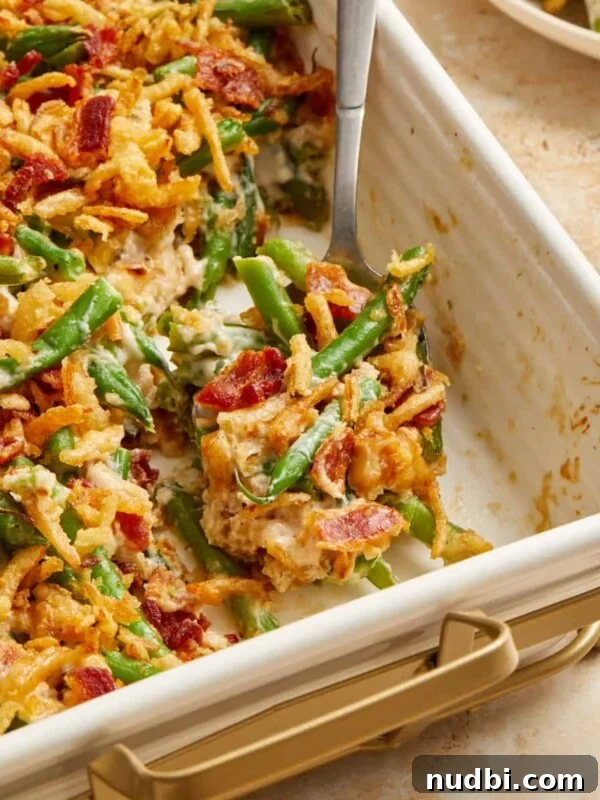 Cheesy Cornbread Casserole Recipe for Comforting Weeknight Dinner 17 Bacon and green bean casserole in pan with serving spoon.