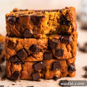 Stack of pumpkin banana bread with chocolate chips slices on top of each other.